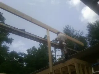 Carpenter setting a ridge beam over a new addition frame — Ice Dam Removal by Roofing Brothers in Billerica
