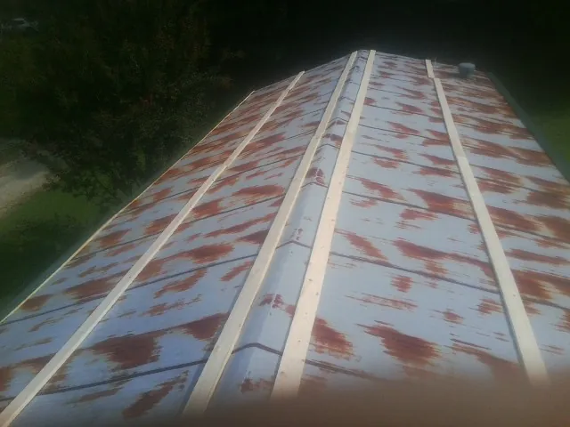Rusted metal roof panels with new wood purlins before replacement — Storm Damage Roof Repair in Billerica by Roofing Brothers