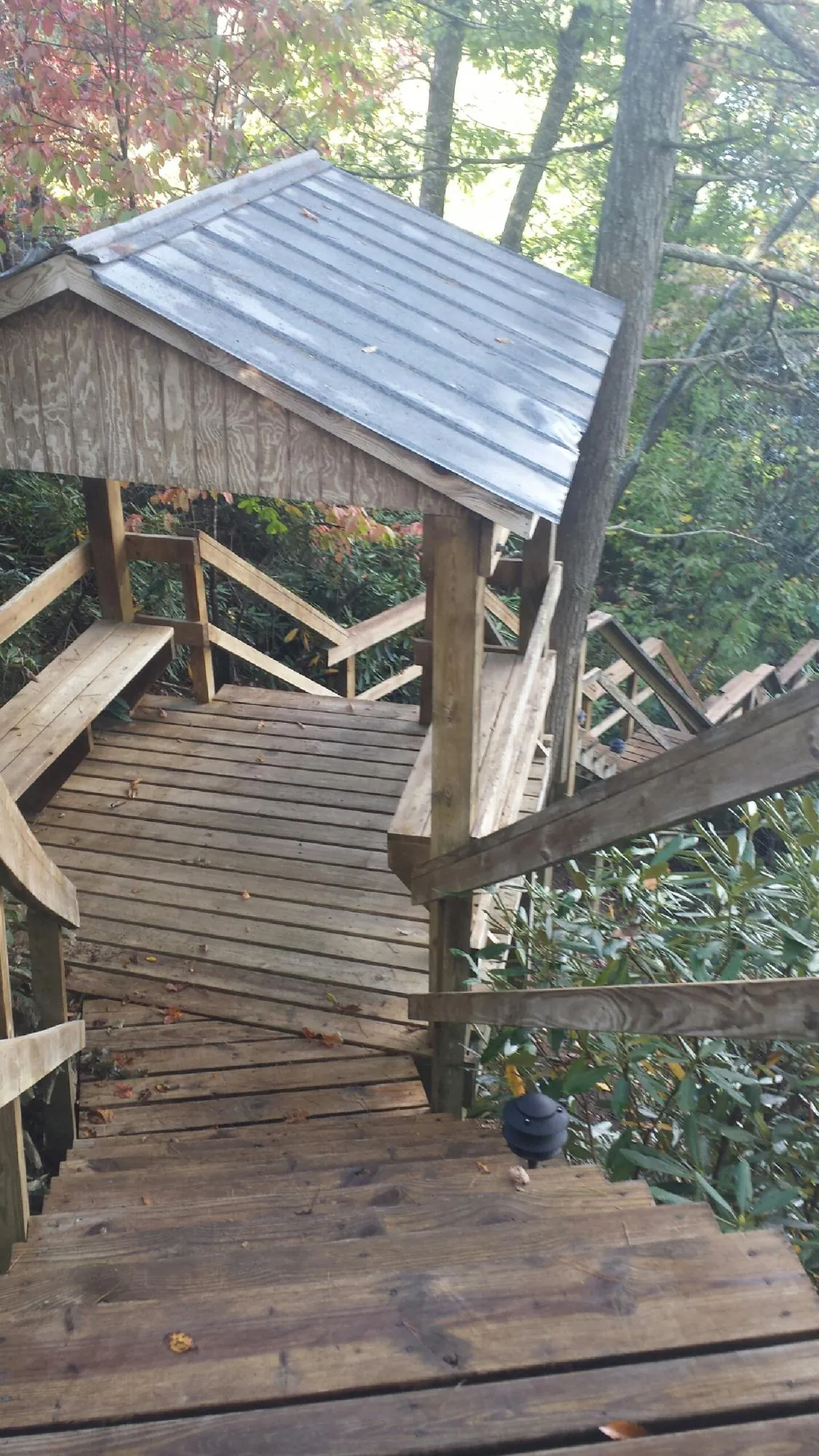 Metal roofed shelter over wooden steps on a wooded walkway — Skylight Repair & Installation work by our crew in Billerica