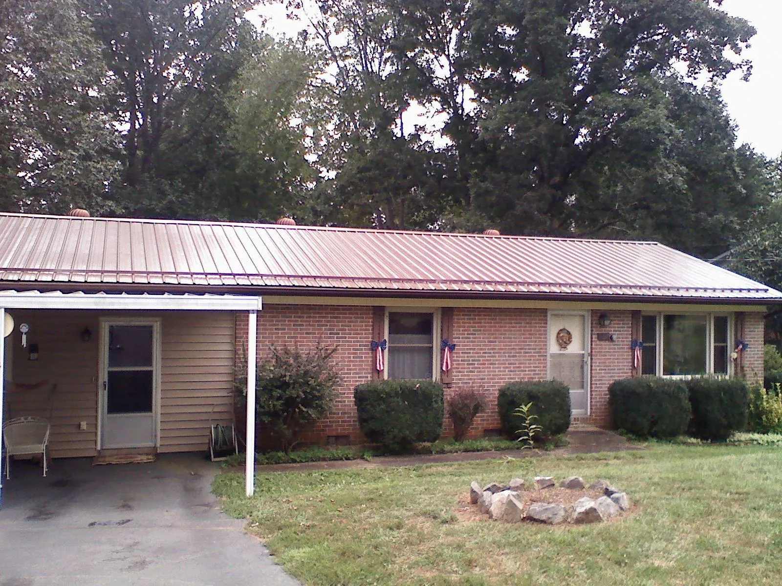 Bronze metal roof and carport on a brick ranch home — Roof Repair work by our crew in Billerica